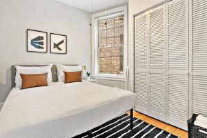 - une chambre blanche avec un grand lit et une fenêtre dans l'établissement Cool 2BR Apartment close to Fun City - Grace 2, à Chicago