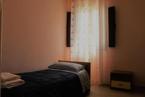 a small bedroom with a bed and a curtain at Agriturismo Tenuta La Siesta in Gallipoli