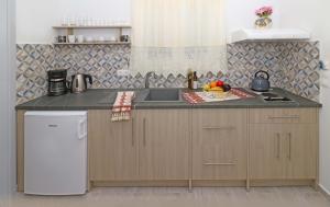 a kitchen with a sink and a counter top at Angela Beach Apartments in Votsalákia +10 photos