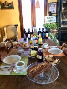 una mesa de madera con comida y botellas de vino en Cascina La Maddalena Bed & Wine, en Rocca Grimalda
