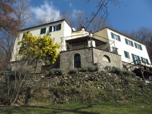 a large white house on top of a stone wall at Villa Maia in Neirone