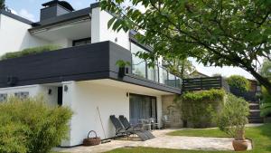 ein weißes Haus mit 2 Stühlen und einer Terrasse in der Unterkunft Ferienwohnung Am Sultmer mit Terrasse und Garten in Northeim