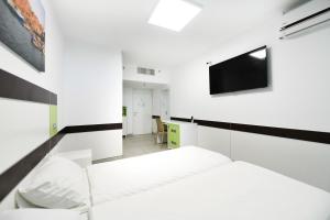a hotel room with a bed and a television at HI - Bnei Dan - Tel Aviv Hostel in Tel Aviv
