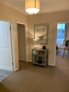 a room with a table with a lamp and a door at Market Hill Apartments in Royston