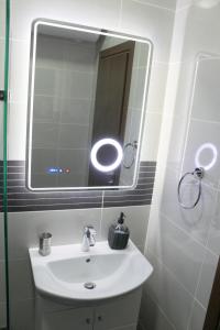 ブルガスにあるSuper Central Luxury Apartmentsのバスルーム(白い洗面台、鏡付)