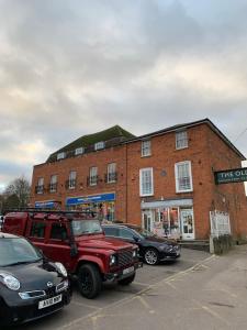 een rode vrachtwagen geparkeerd op een parkeerplaats voor een gebouw bij Market Hill Apartments in Royston