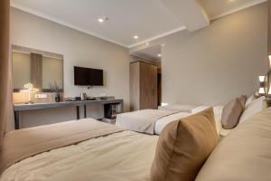 a hotel room with three beds and a television at Sara Boutique Hotel in Bishkek