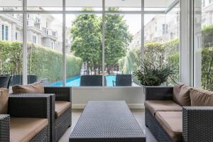 Zimmer mit Stühlen und einem großen Fenster mit Pool in der Unterkunft MIQ Asoke202 Pool Villa - Asoke BTS 16 Pax in Bangkok