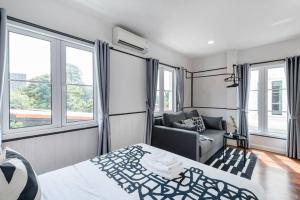 - une chambre avec un lit, un canapé et des fenêtres dans l'établissement MIQ Asoke202 Pool Villa - Asoke BTS 16 Pax, à Bangkok