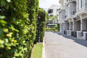 eine Straße, an deren Seite Efeu an einem Gebäude wächst in der Unterkunft MIQ Asoke202 Pool Villa - Asoke BTS 16 Pax in Bangkok