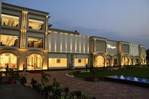 un gran edificio con gente caminando delante de él en Mayur Hotel & Resort, en Sītāpur