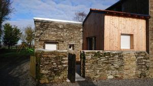 un bâtiment avec un mur en pierre à côté d'une clôture dans l'établissement Domaine du Bel Air, à Casson