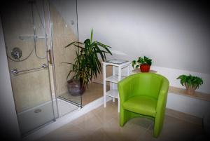 a bathroom with a green chair and a shower at Apartment Renate in Oberasbach