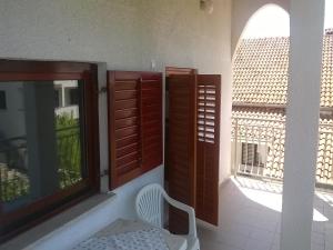 a room with wooden doors and a white chair and a window at Bernie Apartments in Poreč
