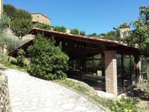 a bridge over a road with a house in the background at Residence Il Monastero in Pomarance