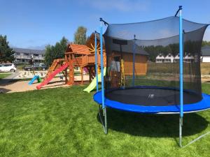 un parque infantil con un trampolín en el césped en Ośrodek Wczasowy Kuba, en Jarosławiec