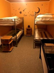 2 Etagenbetten in einem Zimmer mit einer Wand mit Sternen in der Unterkunft Ferienwohnung-Bullendorf in Bullendorf