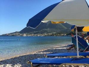 尼基亞娜的住宿－Seaside Family House，海滩上的一组椅子和一把遮阳伞