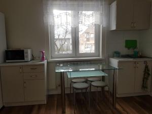 a kitchen with a glass table and two stools at AgroJust in Białowieża