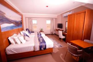 um quarto de hotel com uma cama e uma secretária em Suite blue em Dammam