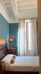 a bedroom with blue walls and a bed and a window at Corso Garibaldi Suite in Milan
