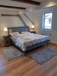 een slaapkamer met een bed, 2 tafels en een raam bij Haus Moritzburg in Bad Schandau