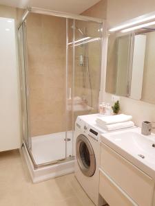 a bathroom with a shower and a washing machine at New CITY CENTER apartments in Druskininkai