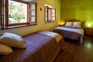 1 dormitorio con 2 camas y ventana en Casa Güela Megustarural, en Llanes