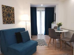 a living room with a blue couch and a table at Moonlight Visoko in Visoko