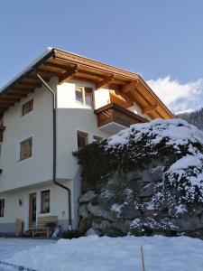 dom z drewnianym dachem w śniegu w obiekcie Apartement Flörl w mieście Rohrberg