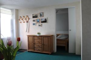 - une chambre avec une commode en bois et un lit dans l'établissement Fischhus Bormann, à Sassnitz