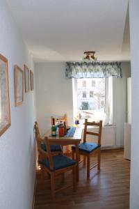 d'une salle à manger avec une table, des chaises et une fenêtre. dans l'établissement Fischhus Bormann, à Sassnitz