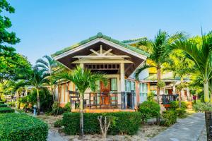 una casa con palmeras delante en Lanta Palm Beach Resort , Beach Front Bungalow - Koh Lanta, en Ko Lanta