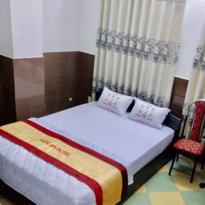 - une chambre avec un lit et deux chaises dans l'établissement Kiến An Hotel Cần Thơ, à Cần Thơ