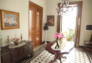 - un salon avec une table et des fleurs dans l'établissement Palazzo al Carmine Dimora Storica, à Castelvetrano