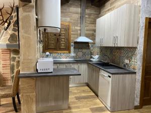 a kitchen with wooden cabinets and a counter top at Casa rural La Marquesa - Cuenca in Valera de Abajo