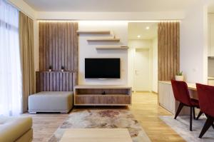 ein Wohnzimmer mit einem TV und einer Treppe in der Unterkunft MVP apartment - Belgrade Waterfront in Belgrad
