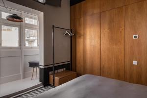 a bedroom with wood paneling and a bed and a window at KUCCA Boutique Townhouse in Żebbuġ