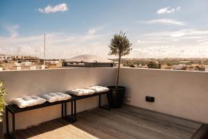 a row of benches on a balcony with a tree at KUCCA Boutique Townhouse in Żebbuġ