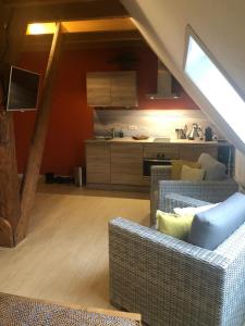 a living room with a couch and a kitchen at B&B Idylle aan Zee incl 2 Wellnessstudios in Sint Maartensvlotbrug