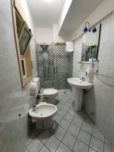 a bathroom with two toilets and a sink at Hotel Casale dei Greci in Biancavilla