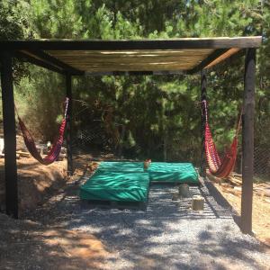 a canopy with a bed and hammocks under it at Acuarela minicasa con piscina en Lago Vichuquen in Vichuquén