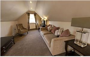 a living room with a couch and a chair at Dumfries Arms Hotel in Cumnock