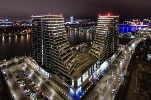 zwei hohe Gebäude neben dem Wasser in der Nacht in der Unterkunft MVP apartment - Belgrade Waterfront in Belgrad