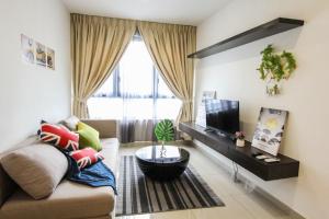 ein Wohnzimmer mit einem Sofa und einem TV in der Unterkunft Your Perfect Stay for Shopping and Entertainment - Hostahome Suites at I-City in Shah Alam