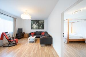 a living room with a couch and a bed at Post Quartier Hinterbrühl in Hinterbrühl