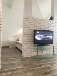 a room with a tv on a brick wall at Comfort place in the city centre in Ivano-Frankivsk
