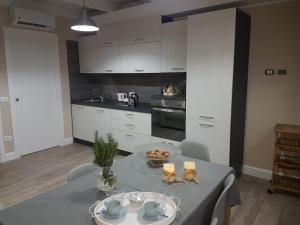 a kitchen with a table and a kitchen with white cabinets at White House in Cagliari