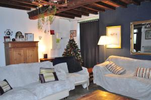 a living room with two couches and a christmas tree at La Maison du Chene in Percy