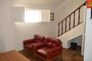 a living room with a brown leather chair and stairs at Hotel Vasco Da Gama in Monte Gordo